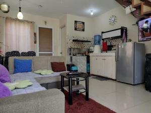 a living room with a couch and a refrigerator at Eurie's Furnished Unit in Butuan