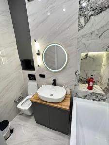 La salle de bains est pourvue d'un lavabo, de toilettes et d'un miroir. dans l'établissement ЖК2 Estet147, à Almaty
