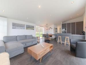 una sala de estar con un sofá y una mesa en Modern chalet at the edge of a forest, en Wemeldinge