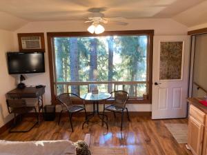 a living room with a table and chairs and a window at Hideaway Ranch in Bonners Ferry