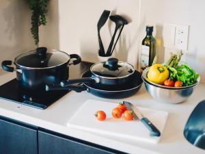 a kitchen counter with a pot and vegetables on a cutting board at MIMARU Tokyo Hatchobori in Tokyo
