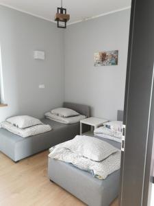 a room with three beds and a table at Tarasy Anastazewa in Anastazewo