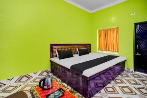 - une chambre avec un lit aux murs verts et une table dans l'établissement OYO Flagship HOTEL OM PALACE & BANQUET HALL, à Deoghar