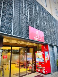 una tienda frente a un edificio con un cartel. en 嵐 Hotel Arashi 難波店 en Osaka