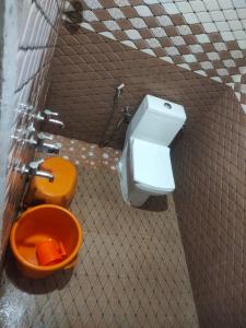 een badkamer met een oranje toilet in een stal bij Eastern Giri home stay in Attigundi