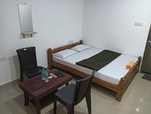een slaapkamer met een bed en een tafel en stoelen bij Eastern Giri home stay in Attigundi