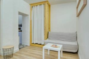 uma sala de estar com um sofá branco e uma mesa em Albertas Furnished studio em Aix-en-Provence