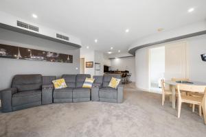 a living room with a couch and a table at East Melbourne 2BR Apartment in Melbourne