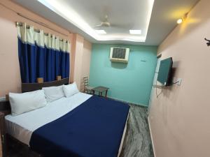 a room with a bed and a tv in it at Hotel Dakshin Sea Paradise in Visakhapatnam