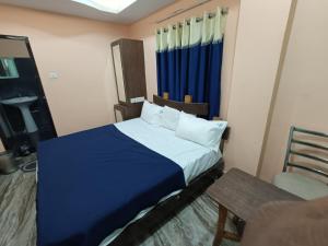 a small bedroom with a bed and a chair at Hotel Dakshin Sea Paradise in Visakhapatnam