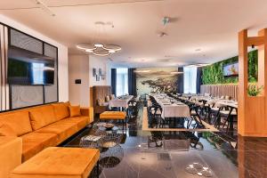 ein Restaurant mit einem Sofa, Tischen und Stühlen in der Unterkunft Hotel Boka in Kotor