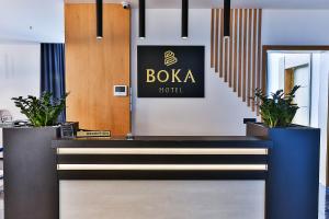 a lobby with a boda hotel sign and potted plants at Hotel Boka in Kotor