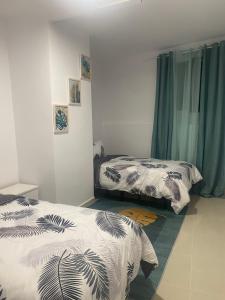 - une chambre avec 2 lits et des rideaux bleus dans l'établissement Alojamiento los Abuelos 3, à Icod de los Vinos