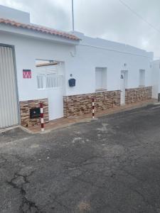 - un bâtiment blanc avec un parking en face dans l'établissement Alojamiento los Abuelos 3, à Icod de los Vinos