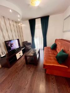 a living room with a couch and a television at Guesthouse Civovic in Bar