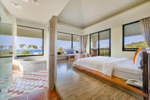a bedroom with a bed and a view of the ocean at Southern Sun Homestay North in Kenting