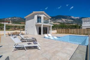 a villa with a swimming pool and a house at Endless Blue Private Club in Trapezaki
