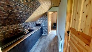 a kitchen with a stone wall and a counter at Do Słońca in Ropienka