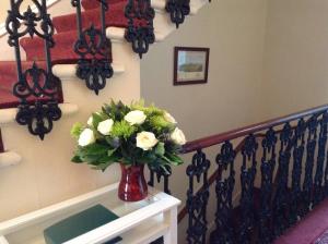 a vase filled with flowers on top of a wall at Ailsa Guest House in Edinburgh