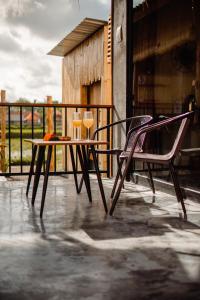 einen Tisch mit zwei Stühlen und zwei Gläsern auf einer Veranda in der Unterkunft Nila Chandra Bungalows in Ubud
