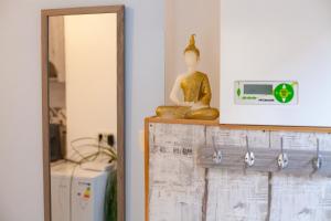 een boeddha standbeeld op een plank naast een spiegel bij Cozy Studio Apartment in Arad City Center in Arad