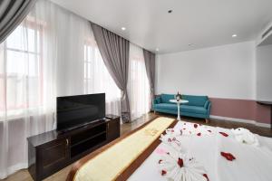 sala de estar con cama y TV de pantalla plana en Harry Phu Quoc Hotel 3, en Phu Quoc