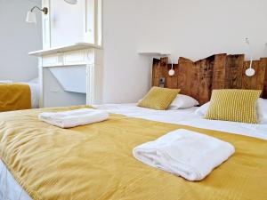 Dos camas con toallas encima. en Au Pont Vieux, en Espalion