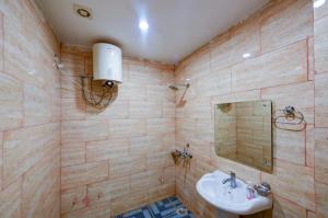 a bathroom with a sink and a mirror at Chauhan Hospitality IGI Airport New Delhi Mahipalpur in New Delhi
