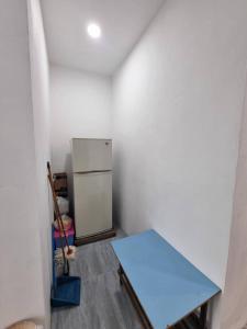 una camera con tavolo blu e frigorifero di Happy Living a Sibu