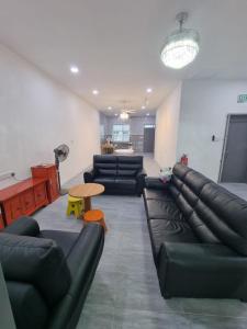 sala de estar con sofá de cuero y mesa en Happy Living, en Sibu