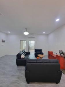 ein Wohnzimmer mit zwei schwarzen Sofas und einem Tisch in der Unterkunft Happy Living in Sibu