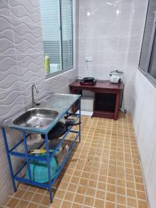 eine Küche mit Spüle und Fliesenboden in der Unterkunft Happy Living in Sibu