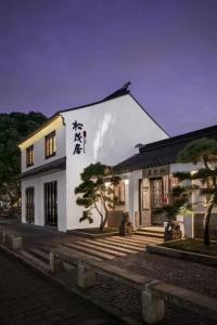 un edificio blanco con escritura china a un lado. en Yihe Riverside Suzhou en Suzhou