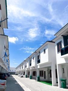 een rij witte gebouwen met de oceaan op de achtergrond bij Honey homes in Lekki