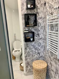 ein Bad mit WC und schwarz-weiße Tapeten in der Unterkunft Chez Tess in Metz