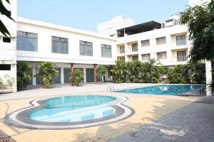 a swimming pool in front of a building at Pushpak Resort in Shirdi