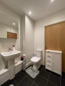 a white bathroom with a sink and a toilet at Peaceful shared flat 30mins Central London in Colindale