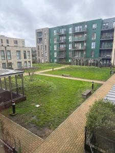 a park in the middle of a city with tall buildings at Peaceful shared flat 30mins Central London in Colindale