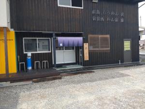 een gebouw met een deur en stoelen ervoor bij Naoshima Accommodation Menjuku Ura - Vacation STAY 92589v in Naoshima