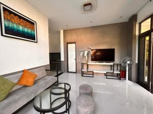 a living room with a couch and a tv at MUN HOMESTAY in Hue
