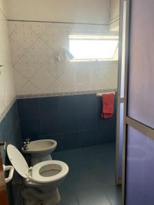 a bathroom with a toilet and a sink at Conti House in Capilla del Monte