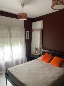 ein Schlafzimmer mit einem Bett mit zwei orangefarbenen Kissen in der Unterkunft Conti House in Capilla del Monte