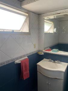 ein Bad mit einem Waschbecken und einem Spiegel in der Unterkunft Conti House in Capilla del Monte