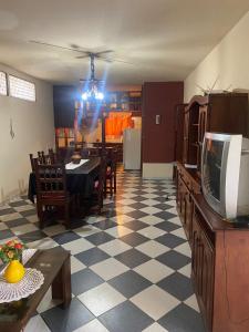 ein Wohnzimmer mit einem TV und einem Esszimmer in der Unterkunft Conti House in Capilla del Monte
