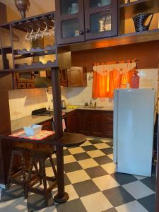 eine Küche mit einem Tisch und einem Kühlschrank in der Unterkunft Conti House in Capilla del Monte