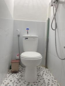 a bathroom with a white toilet and a shower at TRUNG LUONG HOMESTAY in Trung An