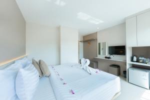 ein Schlafzimmer mit einem großen weißen Bett mit Blumen darauf in der Unterkunft La Vista Patong Hotel in Patong Beach