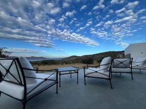 a group of chairs and a table on a roof at Villa Serene Milos in Empourios