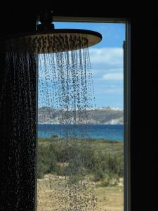 a shower with water pouring out of a window at Villa Serene Milos in Empourios