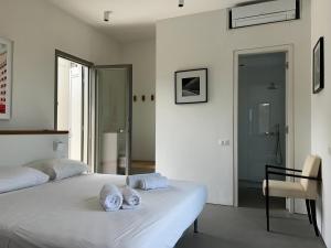 a bedroom with a white bed with towels on it at Villa Serene Milos in Empourios